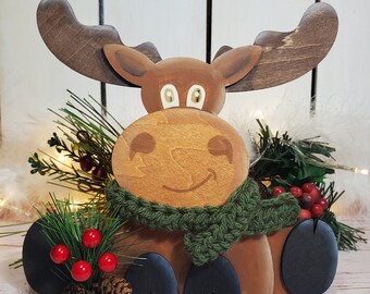 May include: Wooden moose figurine with a green scarf, red berries, and pine branches. The moose has a smiling face and black hooves. The text "Cutting Chaos Designs" and "DIGITAL DOWNLOAD" is visible at the bottom of the image.