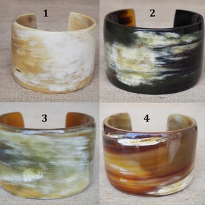 May include: Four horn bracelets in different colors and patterns. The bracelets are made of natural horn and have a polished finish. The bracelets are numbered 1 through 4.