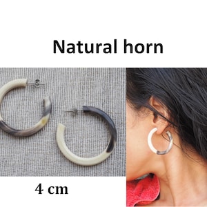 May include: A pair of natural horn hoop earrings in a cream and brown colour. The earrings are 4 cm in diameter.