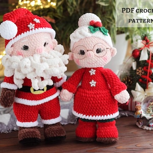 May include: Crocheted Santa Claus and Mrs. Claus dolls. Santa wears a red suit with a white beard, hat, and belt. Mrs. Claus is in a red dress, glasses, and a white bun. The dolls are handmade and festive.