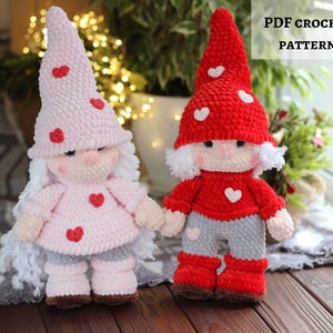 Puede incluir: Dos gnomos de ganchillo hechos a mano. Uno es rosa con corazones rojos, el otro es rojo con corazones blancos. Ambos tienen barbas blancas, pantalones grises y sombreros y botas a juego. El texto "PDF CROCHET PATTERN" es visible.