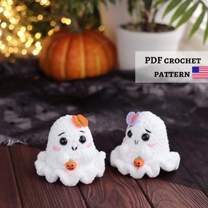 Peut inclure: Deux figurines de fantômes crochetées en blanc avec des yeux de sécurité noirs, des joues roses et de petites citrouilles orange tenues dans leurs mains. Un fantôme porte un nœud orange, l'autre un nœud violet. Texte PDF CROCHET PATTERN.