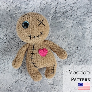 Puede incluir: Patrón de crochet para un muñeco vudú con un corazón rosa, un ojo azul y detalles cosidos. El patrón está disponible para descargar en PDF. Patrón de muñeco vudú PDF.