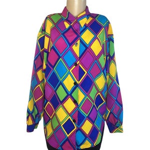 May include: A long-sleeved button-down shirt with a vibrant diamond pattern in shades of yellow, blue, green, purple, and pink. The shirt has a classic collar and black buttons. The sleeves have blue cuffs.