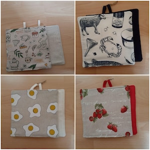 Könnte beinhalten: Vier quadratische Topflappen aus Stoff mit Aufhängeschlaufen. Designs umfassen Tee und Gebäck, ein Schaf und Meeresfrüchte, Spiegeleier und Erdbeeren. Jeder Topflappen hat ein anderes Muster und Farbschema, mit neutralen und hellen Tönen.