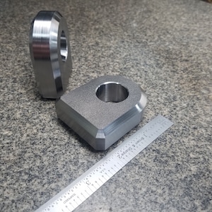 Puede incluir: Dos anillos de metal plateado con un acabado liso. Los anillos son de diferentes tama&ntilde;os y tienen un agujero en el centro. Una regla est&aacute; en el fondo.
