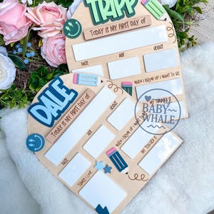 May include: Two wooden first day of school signs. One sign has the name "TRIPP" in green, the other has "DALE" in blue. Both signs have spaces for date, age, weight, and "when I grow up I want to be". Decorative elements include pencils and smiley faces.