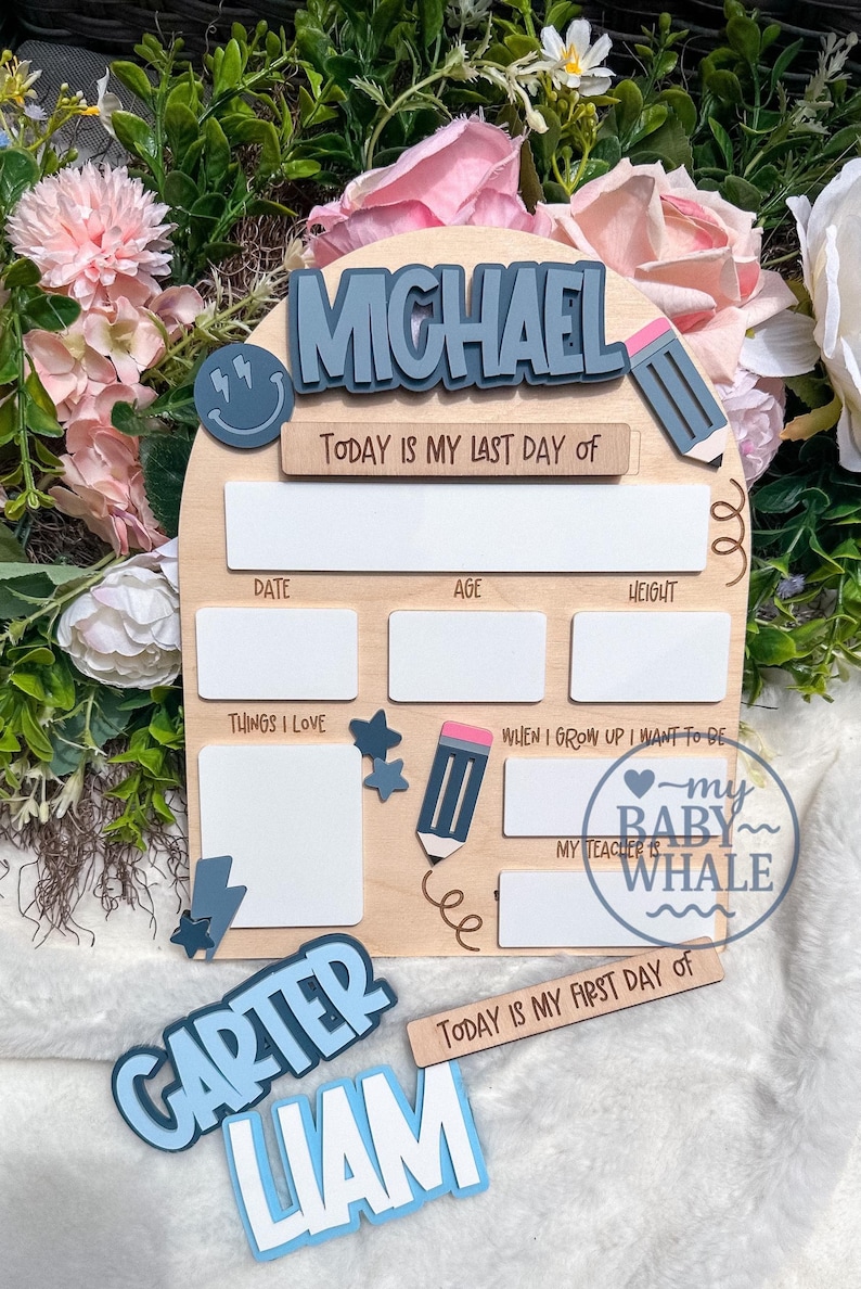 May include: Wooden school memory board with the name "MICHAEL" in blue letters. Includes spaces for date, age, height, and "Things I Love." Features a pencil and star accents, and the text "Today is my last day of" and "Today is my first day of."