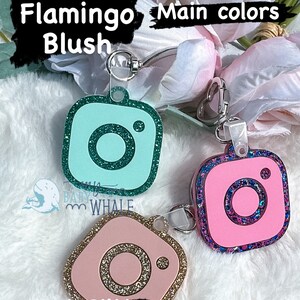 May include: Three Instagram-style keychains with different color combinations. The first keychain is mint green with teal glitter. The second keychain is pink with pink confetti and gold glitter. The third keychain is blush pink with a pink glitter design. The text "Main colors" is written above the keychains and "Icon colors" is written below the keychains.