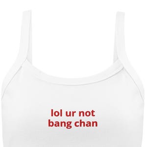 May include: White tank top with red text that says "lol ur not bang chan".