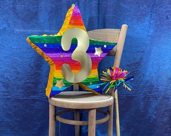 Number Three piñata, add cheer to your anniversary or third birthday party with an oversized gold #3 on a bright rainbow coloured star