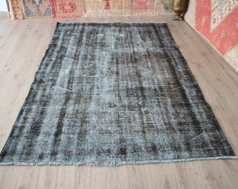 May include: A vintage blue and black rug with a distressed look. The rug has a fringe border and is made of a soft, woven material.