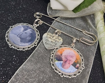May include: A silver safety pin with three charms. One charm is a heart with the text "You are always in my heart". The other two charms are round and feature photos of a young boy and a woman.