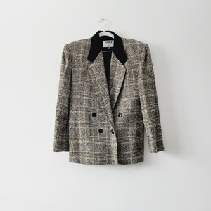 May include: A black and white plaid blazer with a black velvet collar. The blazer has a double breasted closure and two buttons. The label on the blazer reads "WAVERLY 42L".