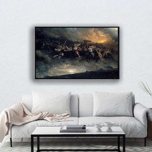 May include: A framed painting showing a dynamic scene with figures in the sky, possibly a battle or mythological event. The artwork features dark, stormy clouds, a bright sunset, and figures in motion. The painting is displayed above a white sofa.