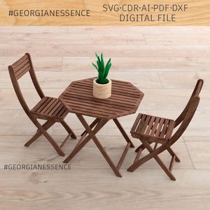 May include: A digital file set labelled #GEORGIANESSENCE containing SVG, CDR, AI, PDF, and DXF formats. The image displays a miniature brown wooden octagonal folding table and two matching folding chairs, with a small potted green plant on top.