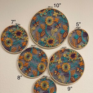 May include: Six embroidery hoops with floral designs in shades of orange, yellow, teal, and purple. The hoops are 5, 6, 7, 8, 9, and 10 inches in diameter. The text "Style 3" is at the top of the image.