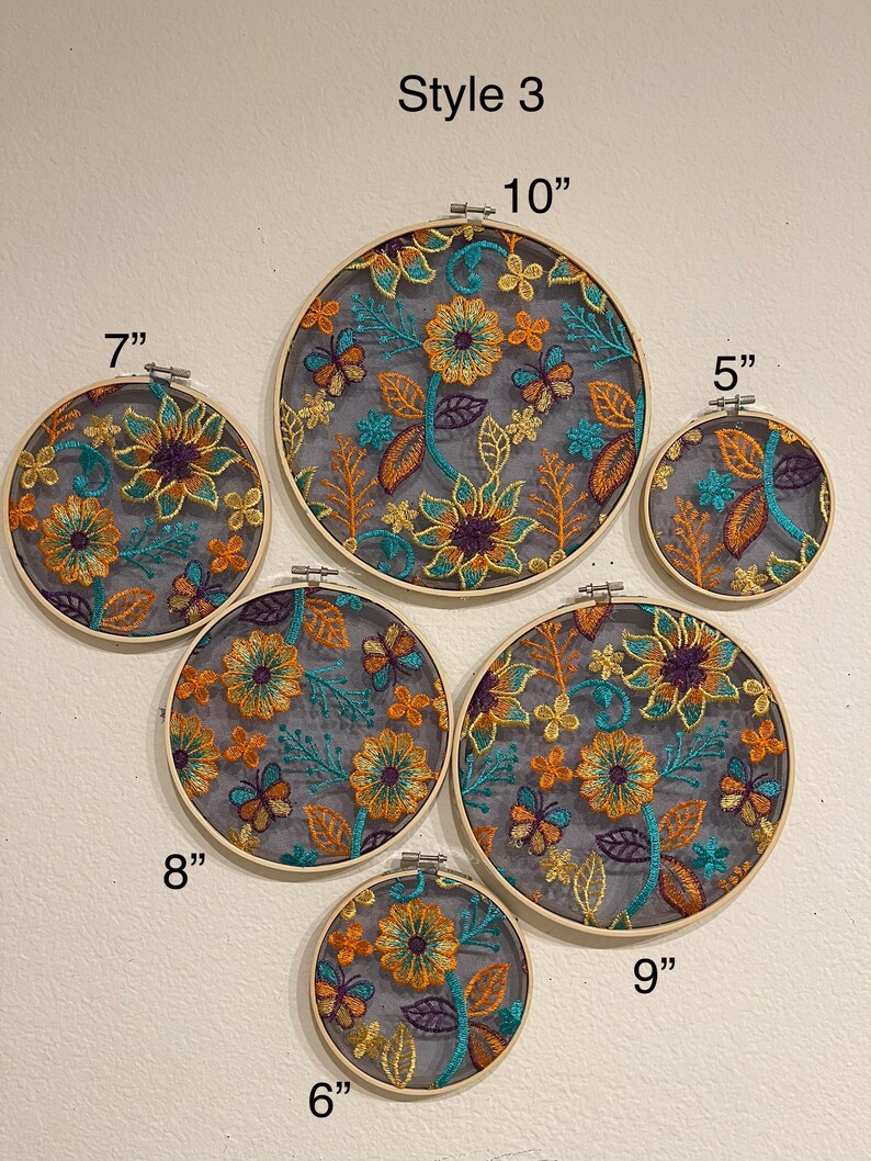 May include: Six embroidery hoops with floral designs in shades of orange, yellow, teal, and purple. The hoops are 5, 6, 7, 8, 9, and 10 inches in diameter. The text "Style 3" is at the top of the image.