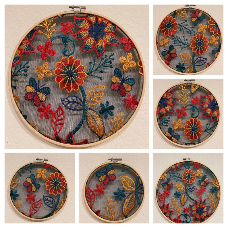 May include: Six embroidered hoop art pieces with floral designs in shades of red, yellow, green, and blue. The designs feature flowers, butterflies, and leaves.