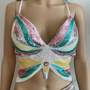 Puede incluir: Un top corto de lentejuelas con un dise&ntilde;o de mariposa en tonos rosa, verde, amarillo y blanco.