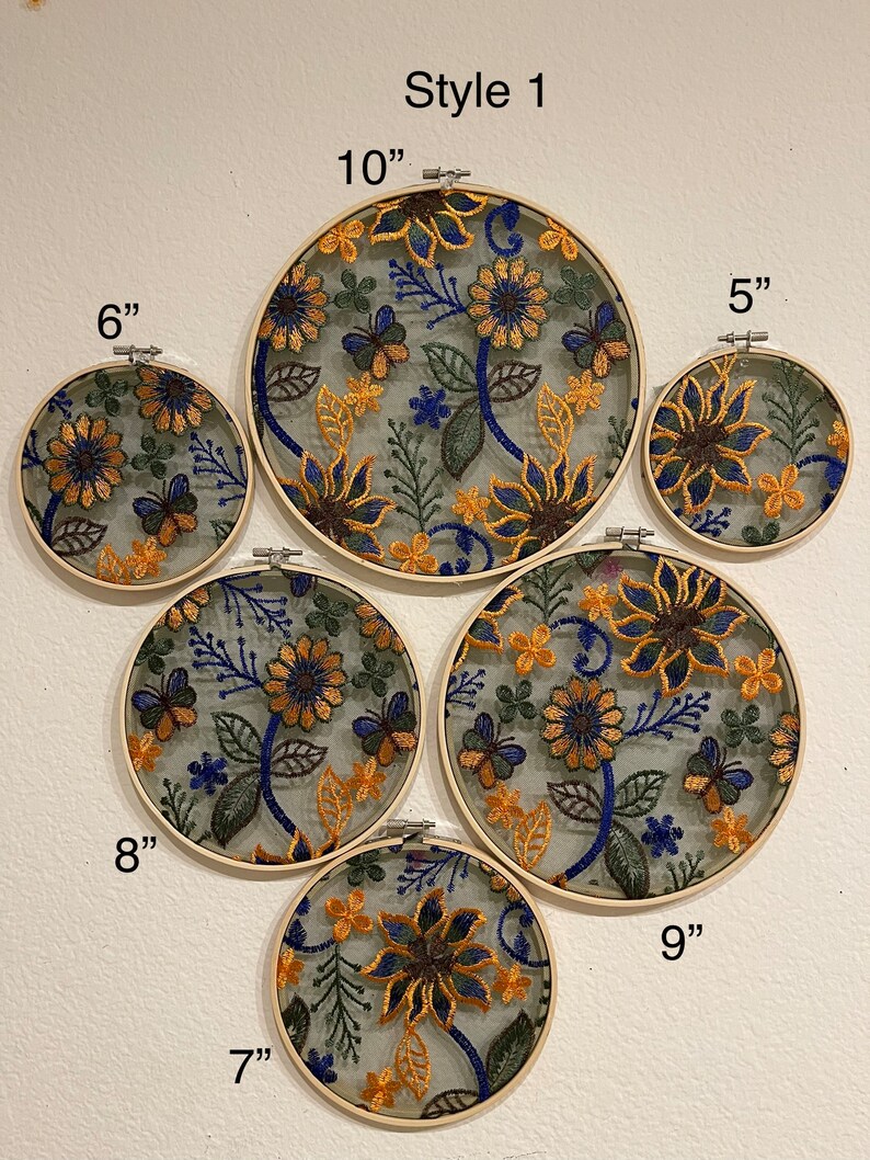 May include: A set of 6 embroidery hoops with floral designs in shades of yellow, blue, and green. The hoops are 5", 6", 7", 8", 9", and 10" in diameter.