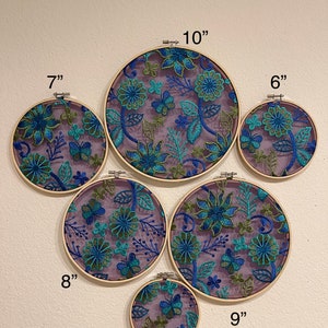 May include: A set of 6 embroidery hoops with floral designs in shades of blue, green, and purple. The hoops are various sizes, ranging from 5 inches to 10 inches in diameter. The text "Style 2" is written at the top of the image.