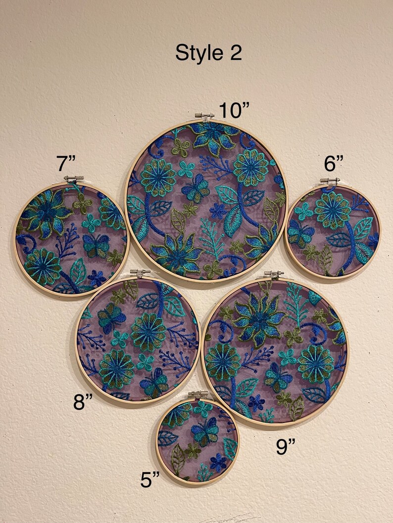 May include: A set of 6 embroidery hoops with floral designs in shades of blue, green, and purple. The hoops are various sizes, ranging from 5 inches to 10 inches in diameter. The text "Style 2" is written at the top of the image.