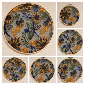 May include: Six embroidery hoops with floral designs. The hoops are made of wood and have a natural finish. The embroidery designs feature yellow, blue, and green flowers and leaves.