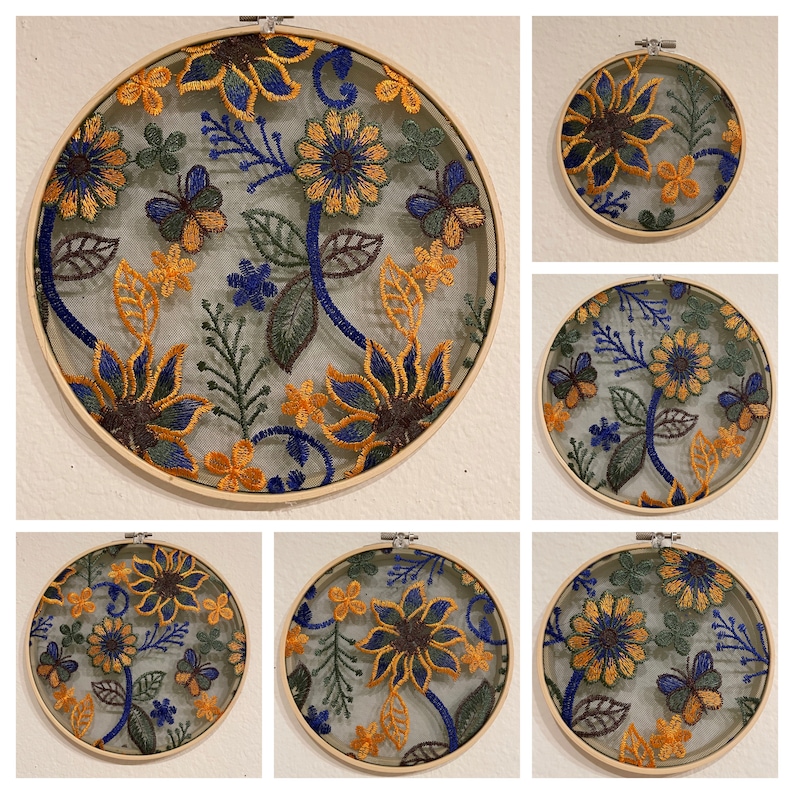 May include: Six embroidery hoops with floral designs. The hoops are made of wood and have a natural finish. The embroidery designs feature yellow, blue, and green flowers and leaves.