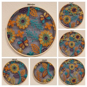 May include: Six embroidery hoops with floral designs on a gray background. The designs feature butterflies, leaves, and flowers in shades of orange, yellow, teal, and purple.
