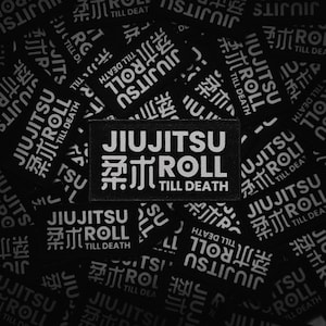 Op de afbeelding: Zwarte rechthoekige patches met de woorden "JIUJITSU ROLL TILL DEATH" in het wit. De patches bevatten ook Japanse karakters. De patches zijn verspreid over een zwarte achtergrond.