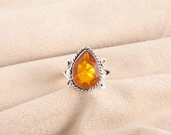 May include: A silver ring with an amber teardrop-shaped gemstone set in a decorative filigree design.