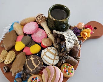 Peut inclure: Une petite planche de service en bois avec une variété de mini pâtisseries, des grains de café et une petite tasse en céramique verte remplie d'un liquide foncé. La planche comprend un petit dipper à miel en bois et des fleurs colorées.