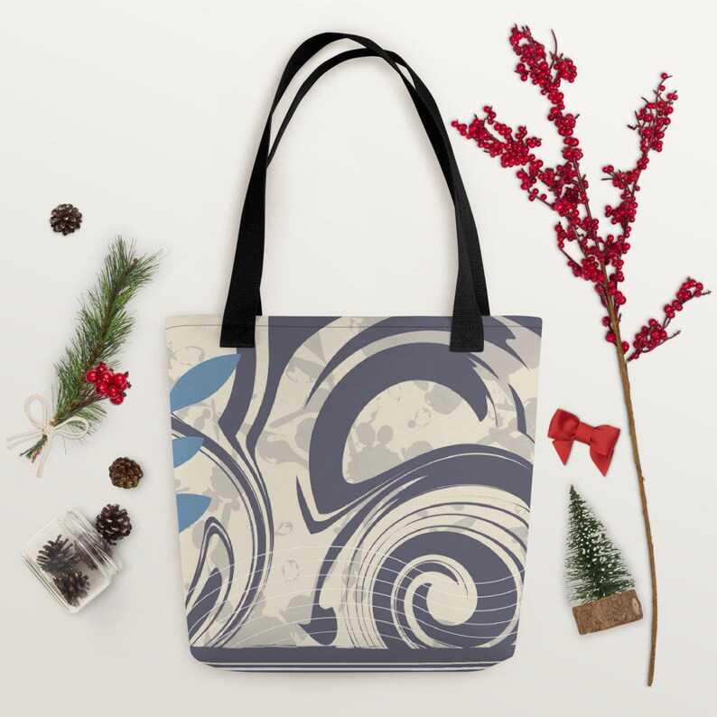 May include: A tote bag with black handles and a cream and purple swirl pattern. The pattern includes blue accents and white lines.