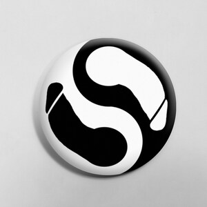 Może przedstawiać: Czarno-biały symbol yin yang z dwoma zakrzywionymi kształtami, jeden czarny, a drugi biały, tworzący okrąg.