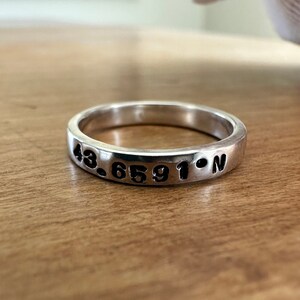 Peut inclure: Une bague en argent avec les coordonnées "43.6591° N" gravées dessus.