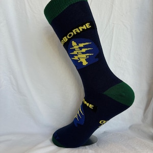 May include: A pair of dark blue socks with a green cuff. The socks feature a yellow and blue graphic of a tree with lightning bolts and the word "AIRBORNE" in yellow letters.