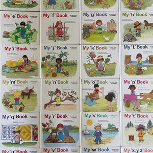 Può includere: Una collezione di libri per bambini intitolati "My a Book" fino a "My x,y,z Book". Ogni copertina presenta illustrazioni colorate di bambini e animali, con il titolo in lettere grandi e in grassetto. I libri fanno parte della serie "My First Steps to Reading".