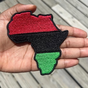May include: A red, black, and green embroidered patch shaped like the continent of Africa.