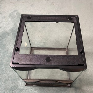 May include: A black glass terrarium with a black plastic lid and a black plastic base. The terrarium is empty.