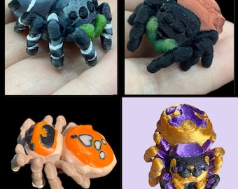 May include: Four 3D printed spider figurines. One is black and white with green accents, one is black with orange accents, one is black with purple and gold accents, and one is orange with black and white accents.