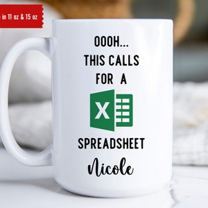 May include: White ceramic mug with a black and green design. The mug reads "OOOH... THIS CALLS FOR A SPREADSHEET Nicole".