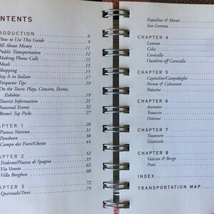 Pu&ograve; includere: Un libro intitolato "Rome's Top Picks" con un indice che elenca diversi capitoli e numeri di pagina per varie localit&agrave; a Roma, Italia. I capitoli includono "Introduzione", "Capitolo 1: Piazza Navona", "Capitolo 2: Tridente/Piazza di Spagna", "Capitolo 3: Quirinale/Trevi", "Capitolo 4: Laterano", "Capitolo 5: Campidoglio", "Capitolo 6: Aventino", "Capitolo 7: Trastevere", "Capitolo 8: Vaticano & Borgo", "Indice" e "Mappa dei trasporti".