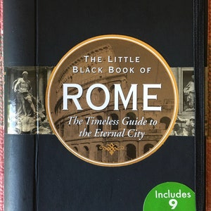 Pu&ograve; includere: Un libro nero rilegato in tela con il titolo "The Little Black Book of Rome: The Timeless Guide to the Eternal City". La copertina presenta un'immagine circolare del Colosseo e un adesivo che dice "Include 9 mappe pieghevoli".