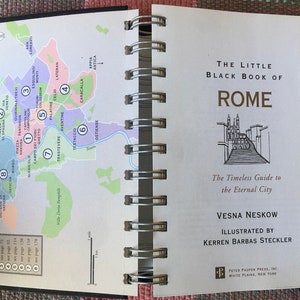 Pu&ograve; includere: Una mappa di Roma, Italia, con aree numerate e numeri di pagina corrispondenti per una guida di viaggio. La guida &egrave; intitolata "The Little Black Book of Rome: The Timeless Guide to the Eternal City" di Vesna Neskow, illustrata da Kerren Barbas Steckler.