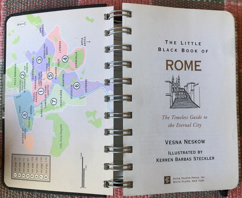 Pu&ograve; includere: Una mappa di Roma, Italia, con aree numerate e numeri di pagina corrispondenti per una guida di viaggio. La guida &egrave; intitolata "The Little Black Book of Rome: The Timeless Guide to the Eternal City" di Vesna Neskow, illustrata da Kerren Barbas Steckler.
