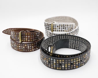 May include: Three leather belts with metal stud embellishments. One belt is brown, another is white, and the third is black. Each belt has a metal buckle. The belts are displayed on a white background.