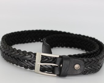 May include: A black braided leather belt with a silver-colored buckle. The belt is made of woven leather and has a classic design. The belt is suitable for casual or formal wear.