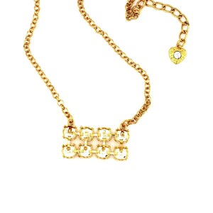 May include: Two gold necklaces with crystal accents. The necklace on the left has clear crystals and the necklace on the right has blue, pink, and red crystals.
