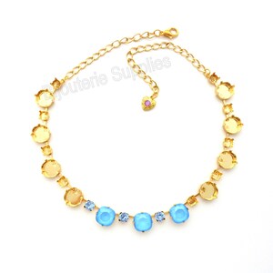 May include: A gold chain necklace with a row of round settings and a row of square settings. The round settings are empty and the square settings are filled with light blue rhinestones.